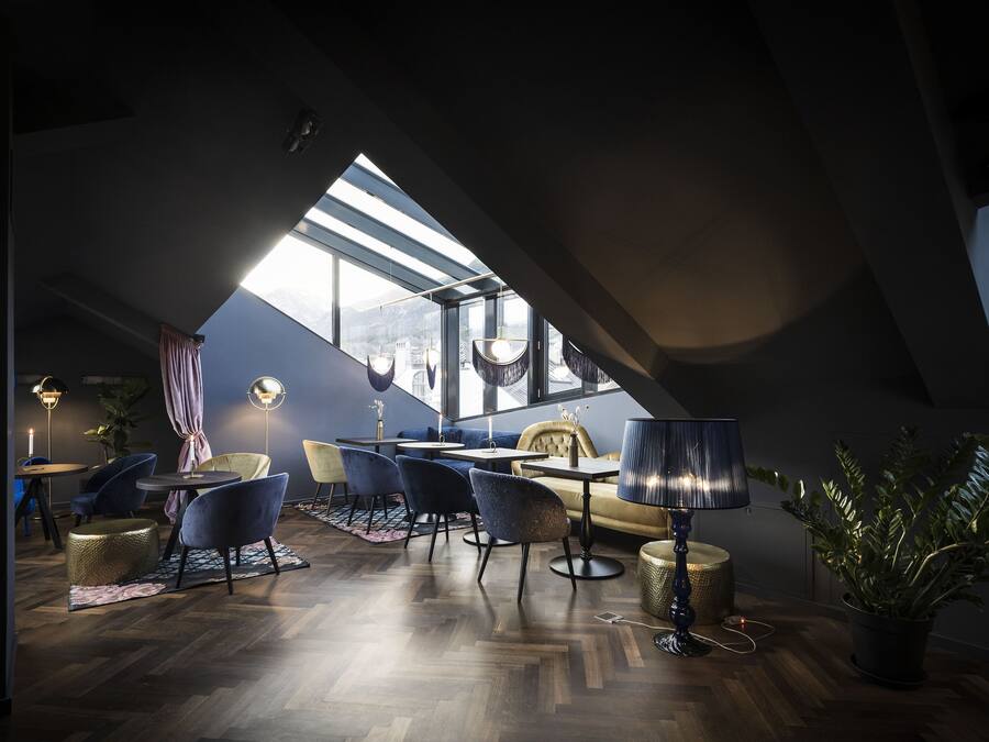 Ein modernes Loft-Zimmer mit Essbereich, Sitzgelegenheiten und einem großen Dachfenster.