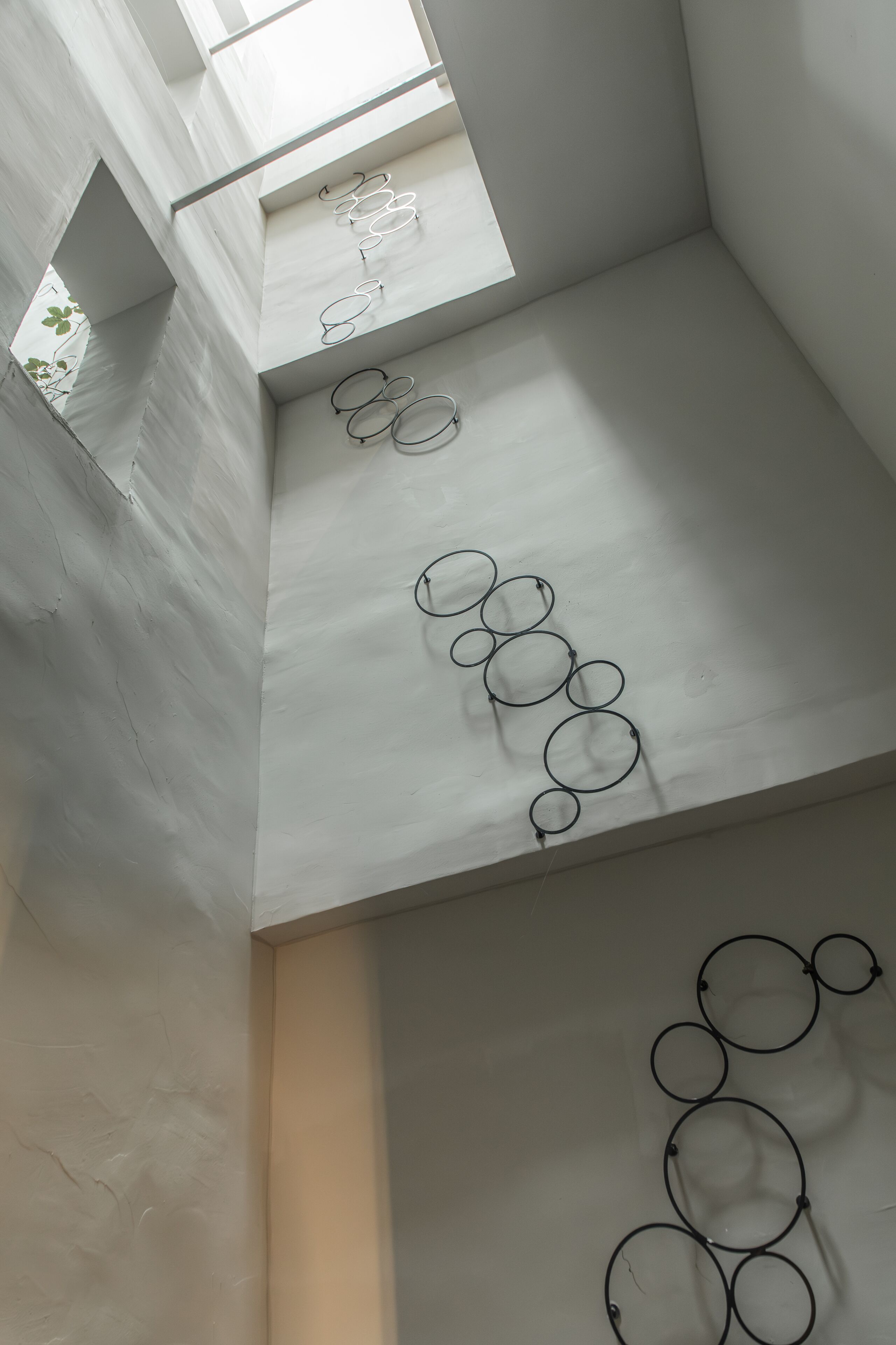 Un interior moderno con un diseño geométrico en el techo y lámparas circulares.