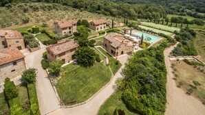 A rural estate with stone buildings, a tennis court, and surrounding greenery. - Poggio Cennina Resort (Bucine)