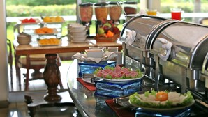 Un bufé con diversos alimentos y un dispensador de bebidas.
