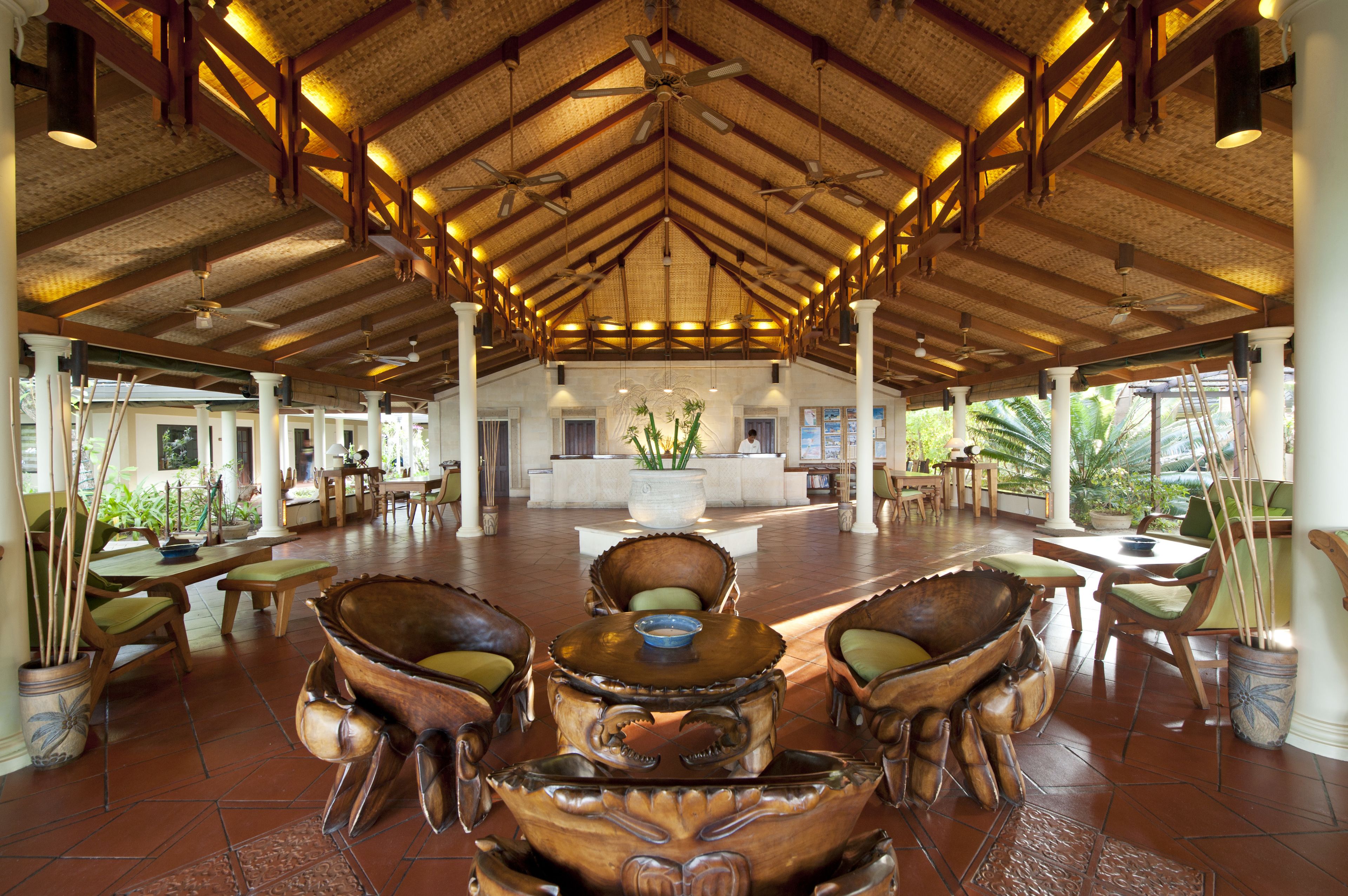 A spacious lobby with a high ceiling, wooden beams, and a central reception desk.