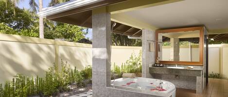 A modern bathroom with a freestanding bathtub, a large mirror, and a sink.
