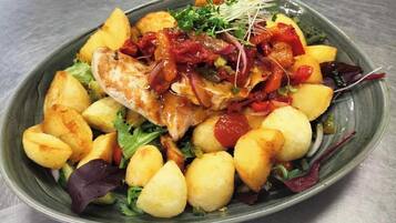 A plate of food with a variety of vegetables and a piece of grilled chicken.