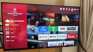A television screen displaying a hotel channel interface with various TV channels and apps. - Station House Hotel (Letterkenny)
