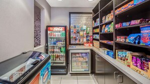 A small convenience store with a Coca-Cola refrigerator, a Nestle refrigerator, and shelves stocked with snacks and beverages. - La Quinta Inn & Suites by Wyndham Modesto Salida (Salida)