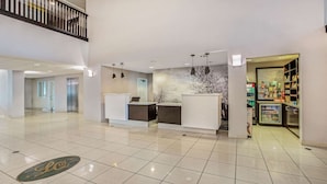 A spacious lobby with a reception desk, a staircase, and a vending machine. - La Quinta Inn & Suites by Wyndham Modesto Salida (Salida)