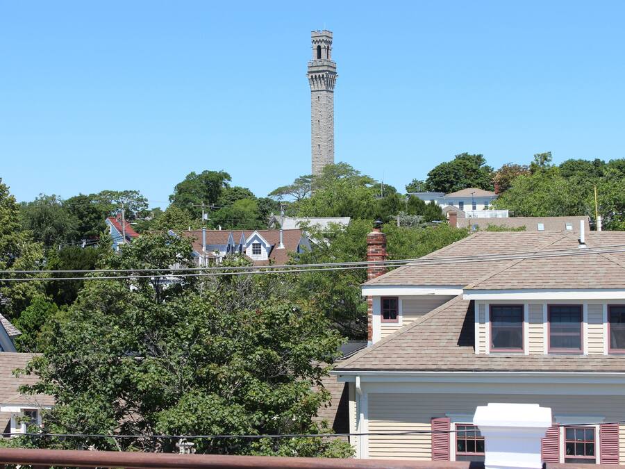 A residential area with a prominent tower in the background, surrounded by houses and trees.