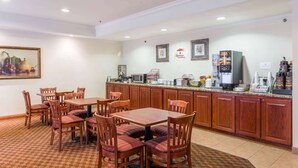 A breakfast area with wooden tables and chairs, a coffee machine, and a refrigerator. - Super 8 by Wyndham St Robert Ft Leonard Wood Area (St. Robert)