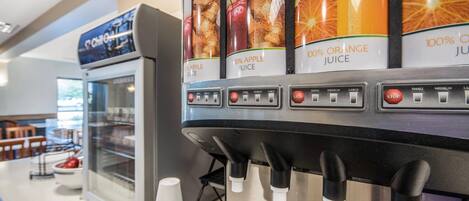 A juice dispenser with options for apple, orange, and 100% orange juice.