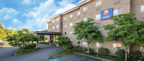 Un hotel Comfort Inn & Suites con estacionamiento, espacios para discapacitados y entrada cubierta.