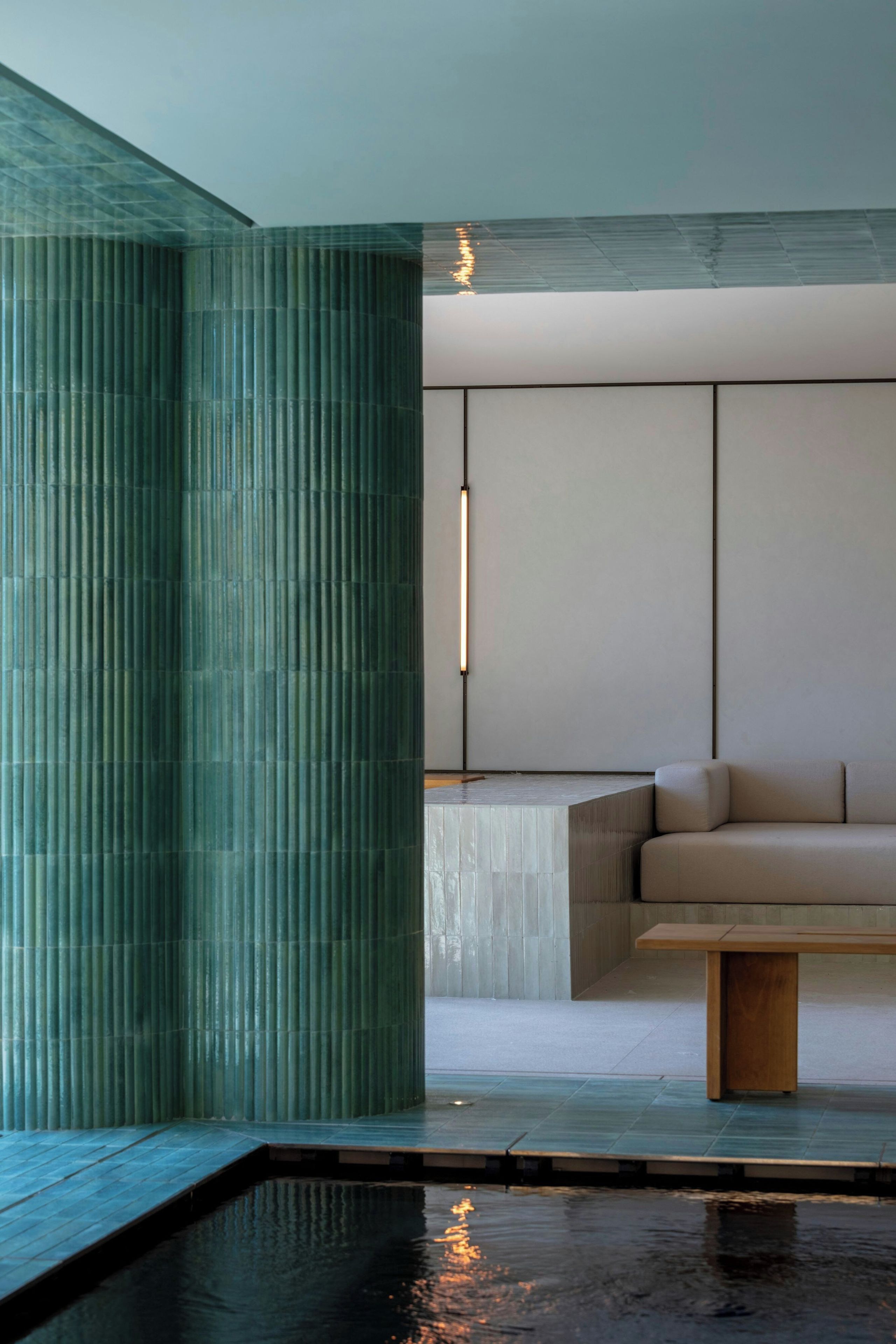 Ein modernes Interieur mit Schwimmbad, einer Couch und einer hohen Säule.