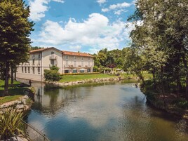 A large building with a courtyard and a pond.