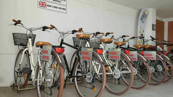 A row of bicycles with 'DAMA HOTEL' signs, indicating a bike rental service at the hotel.
