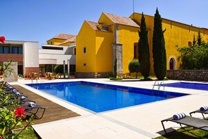 Una piscina al aire libre, tumbonas