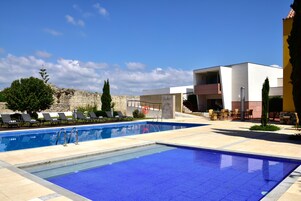Una piscina al aire libre, tumbonas