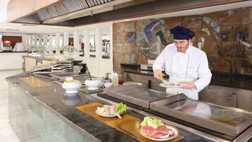 A chef preparing food at a counter with various ingredients and kitchen equipment.