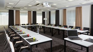 A conference room with a long table, chairs, and a laptop. - Schröder Hotel and Restaurant (Gross Meckelsen)