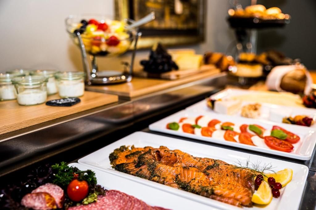 Ein Buffet mit verschiedenen Speisen, darunter Lachs, Gemüse und weitere Gerichte.