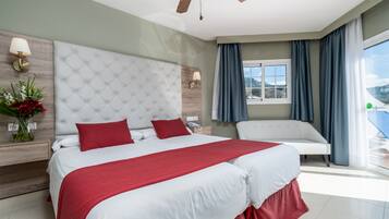 Une chambre d’hôtel moderne, dotée d’un grand lit, d’un canapé, d’une fenêtre avec des rideaux et offrant une vue sur l’extérieur.