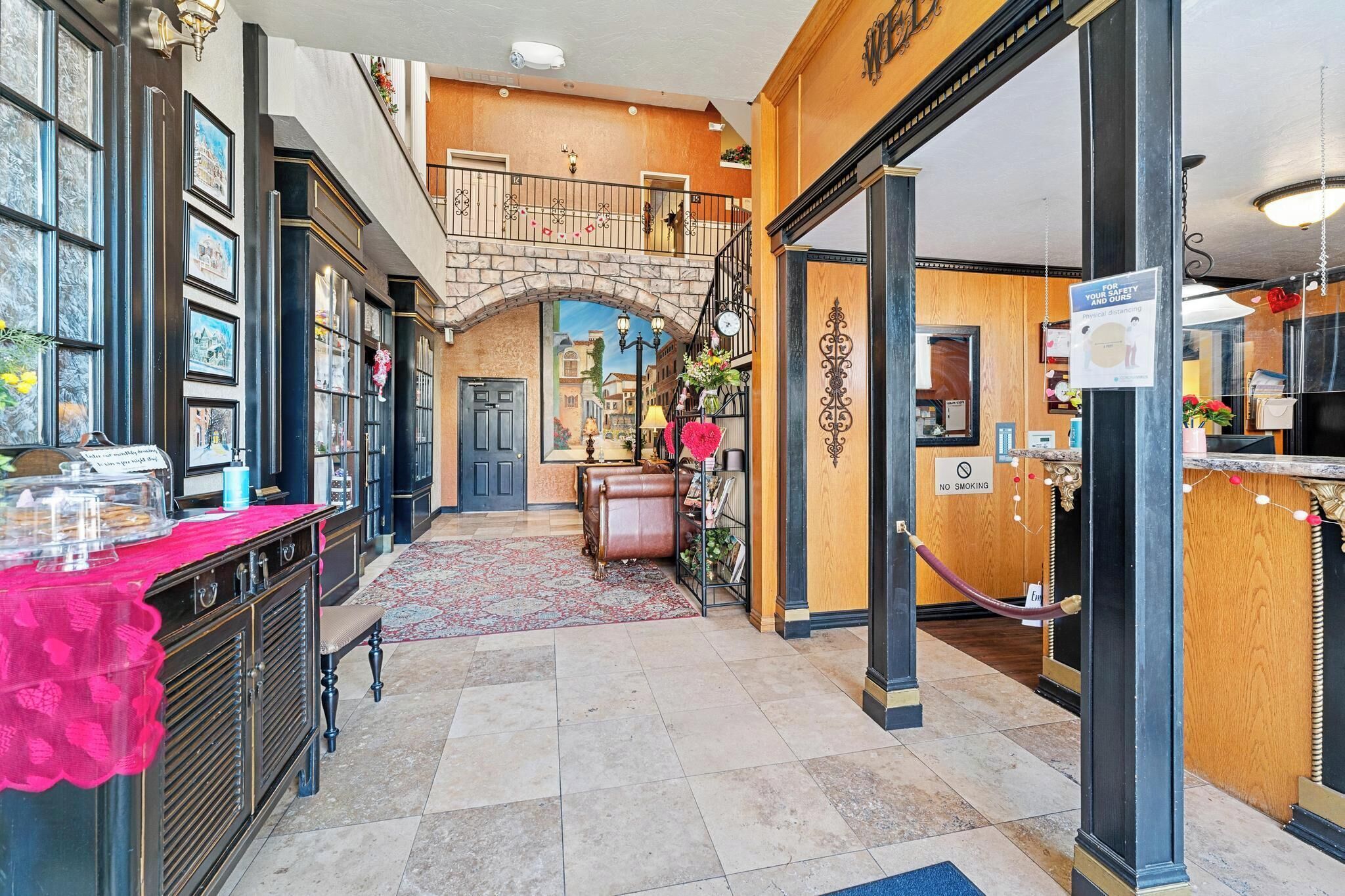 A hotel lobby with a staircase, a reception desk, and a coffee station.