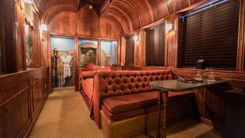 A cozy, wood-paneled interior with a plush red bench and a small table.
