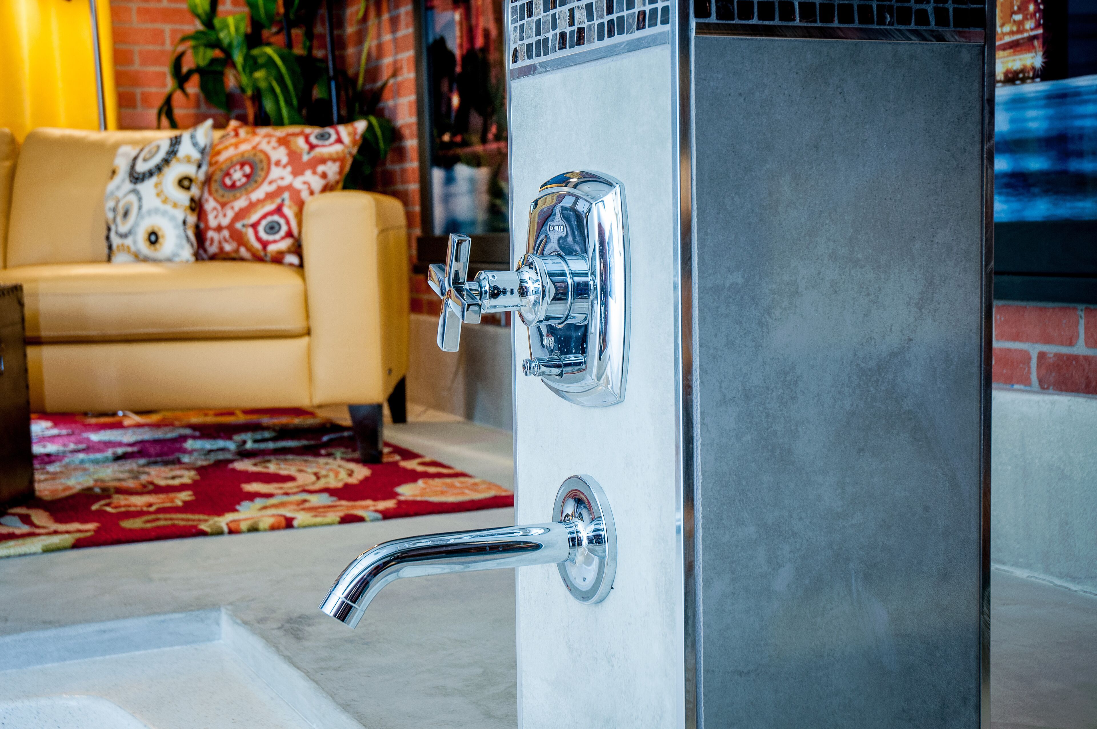 A bathroom with a chrome faucet and a shower control panel.