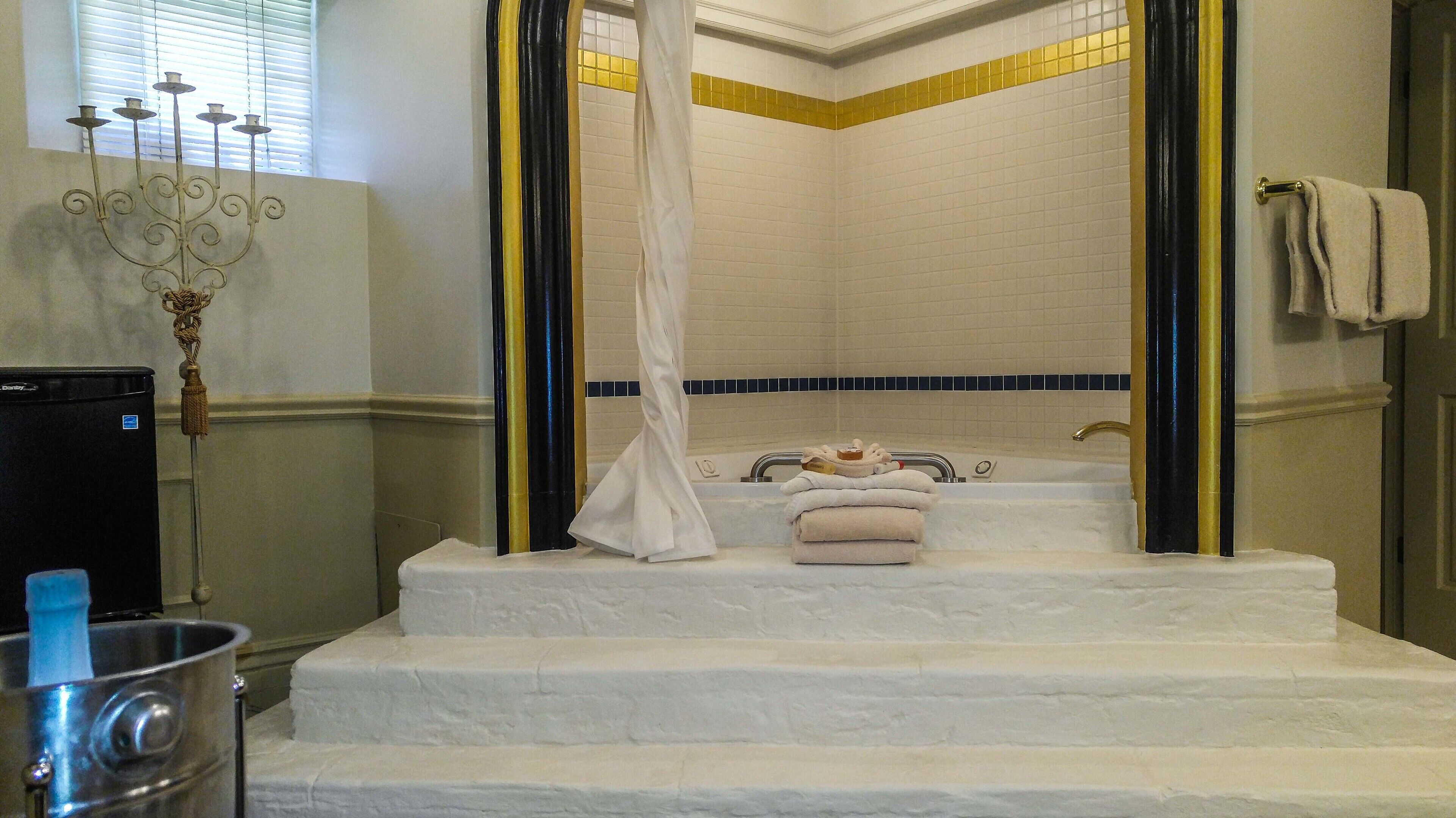 Ein Badezimmer mit einer Badewanne, einem weißen Vorhang und einem Handtuchhalter.