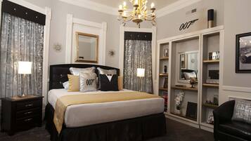 Une chambre à coucher avec un grand lit, un lustre, une armoire et un miroir.
