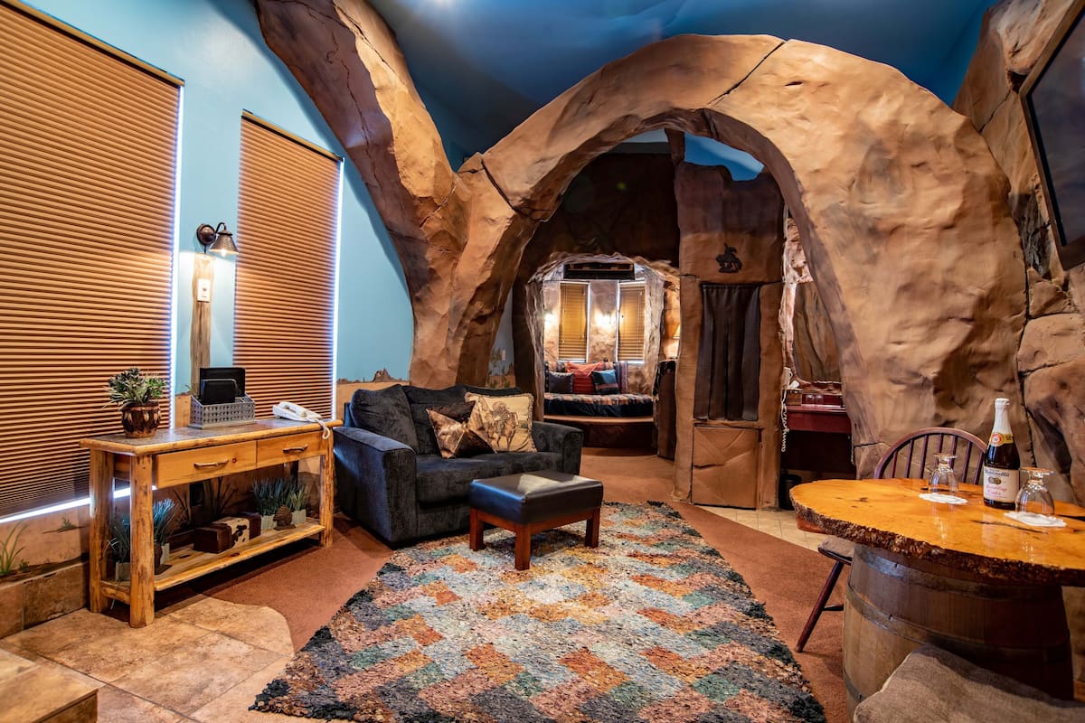 Une pièce chaleureuse avec une table en bois, un canapé et un tapis.