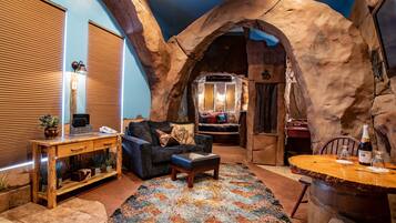 A cozy room with a wooden table, a sofa, and a rug.