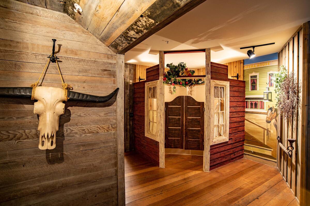 Un intérieur rustique avec des murs en bois, un plancher en bois et une porte donnant sur une autre pièce.