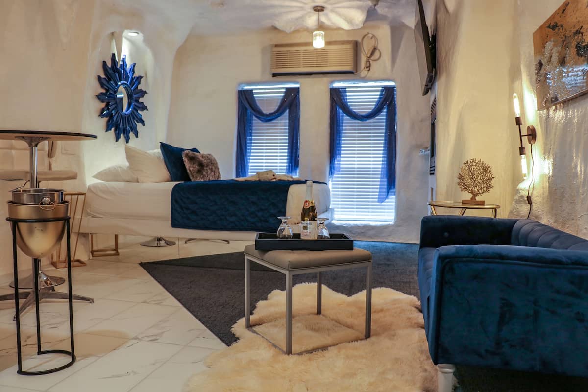 Un salon moderne comprenant un canapé, une table basse, une petite table d’appoint et un miroir décoratif.