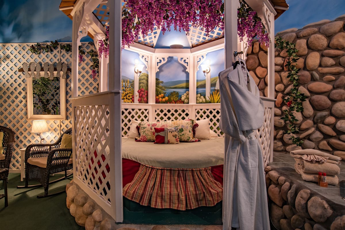Une pièce confortable avec un lit, une chaise et une lampe.