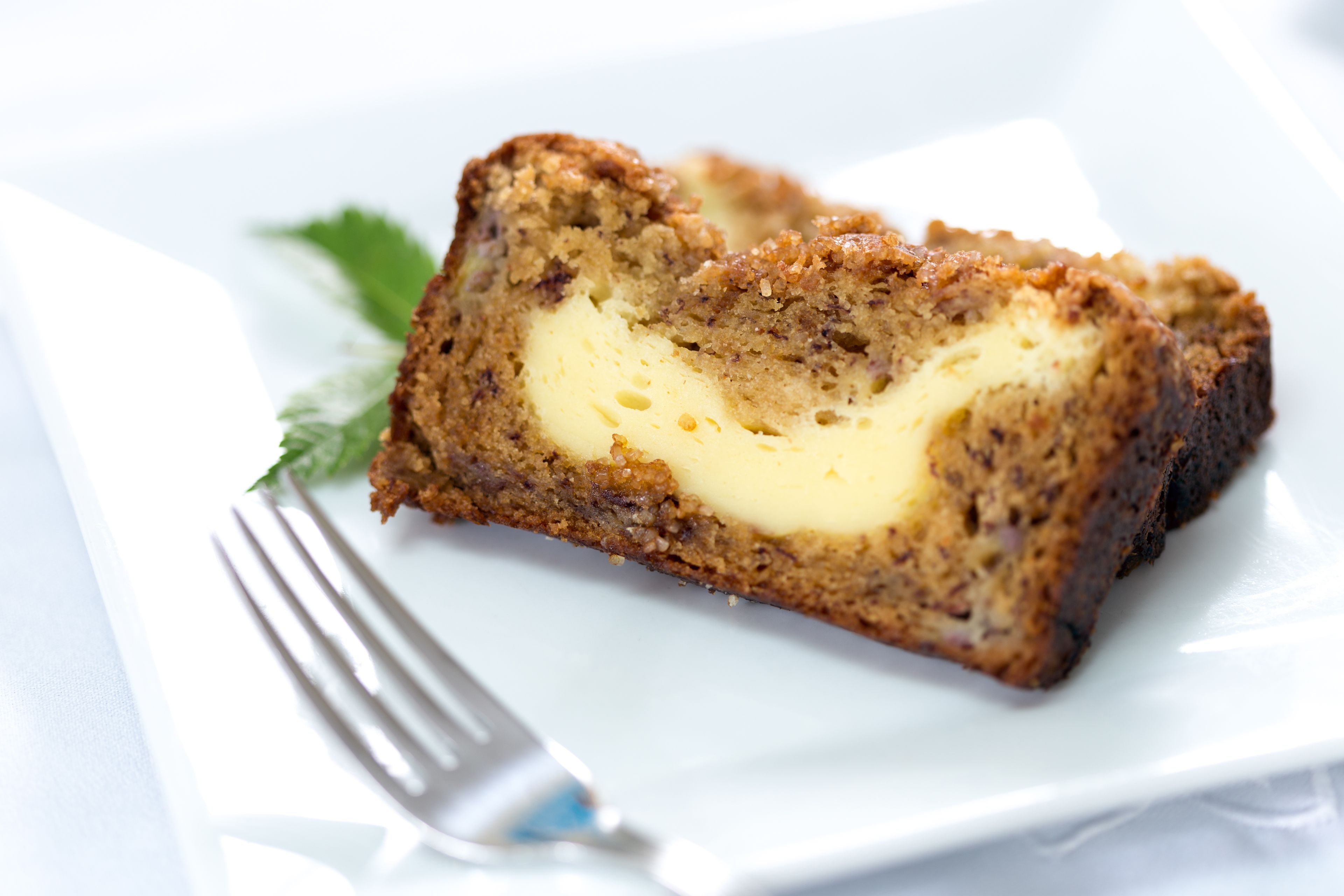 A slice of cake with a creamy filling on a white plate.