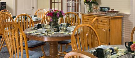 A dining room with a round table, wooden chairs, and a cabinet.