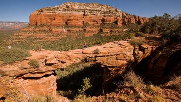 A natural rock formation with a person standing on a ledge.