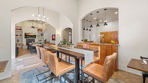 A spacious dining area with a long wooden table, leather chairs, and pendant lighting. - Las Posadas of Sedona (Sedona)