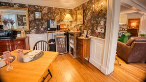 A kitchen with wooden cabinets, a refrigerator, and a dining table with chairs.