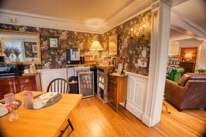A kitchen with wooden cabinets, a refrigerator, and a dining table with chairs.