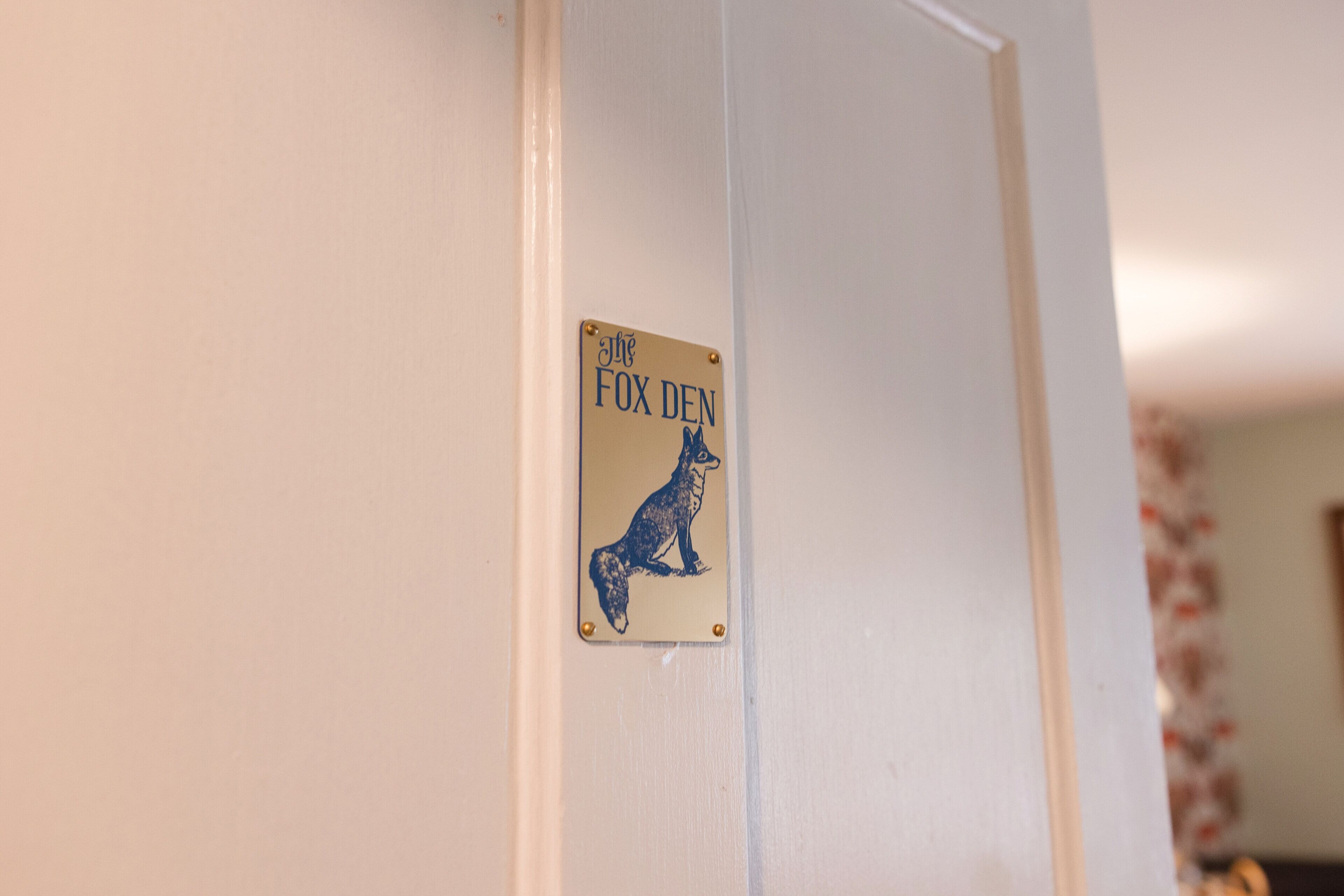 A door with a sign that reads 'The Fox Den.'
