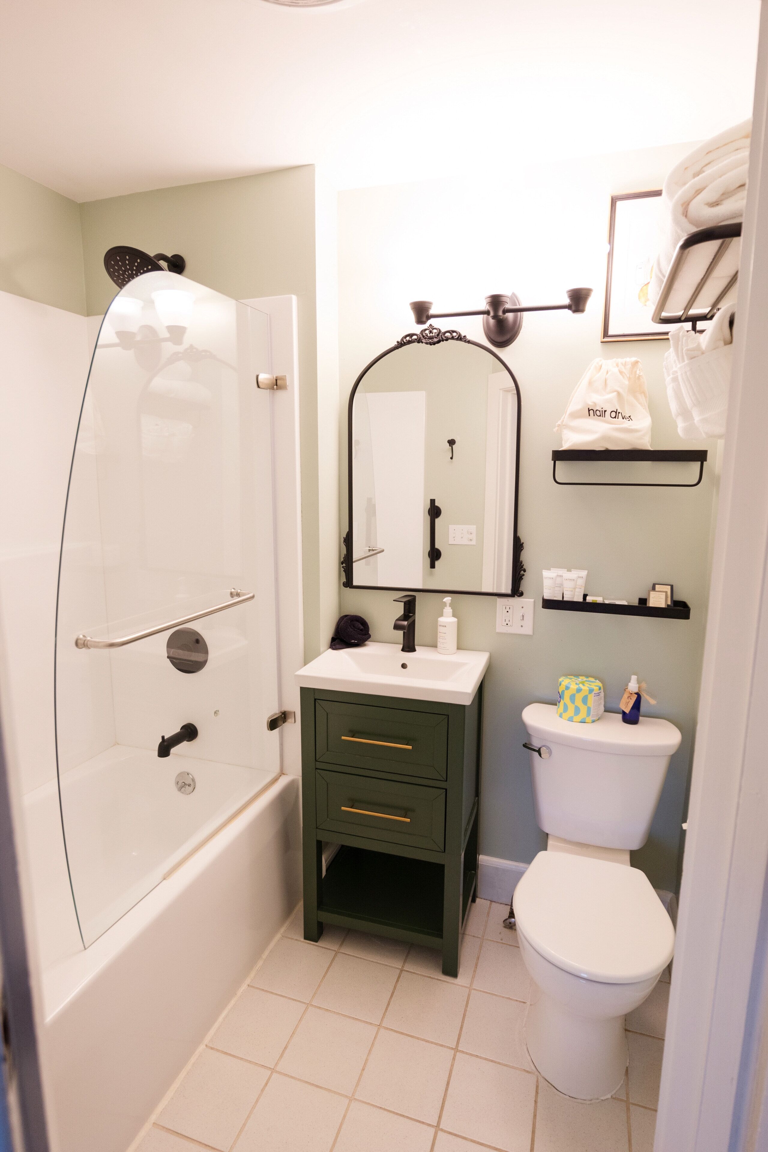 Un bagno completo di doccia, lavandino, WC e specchio.