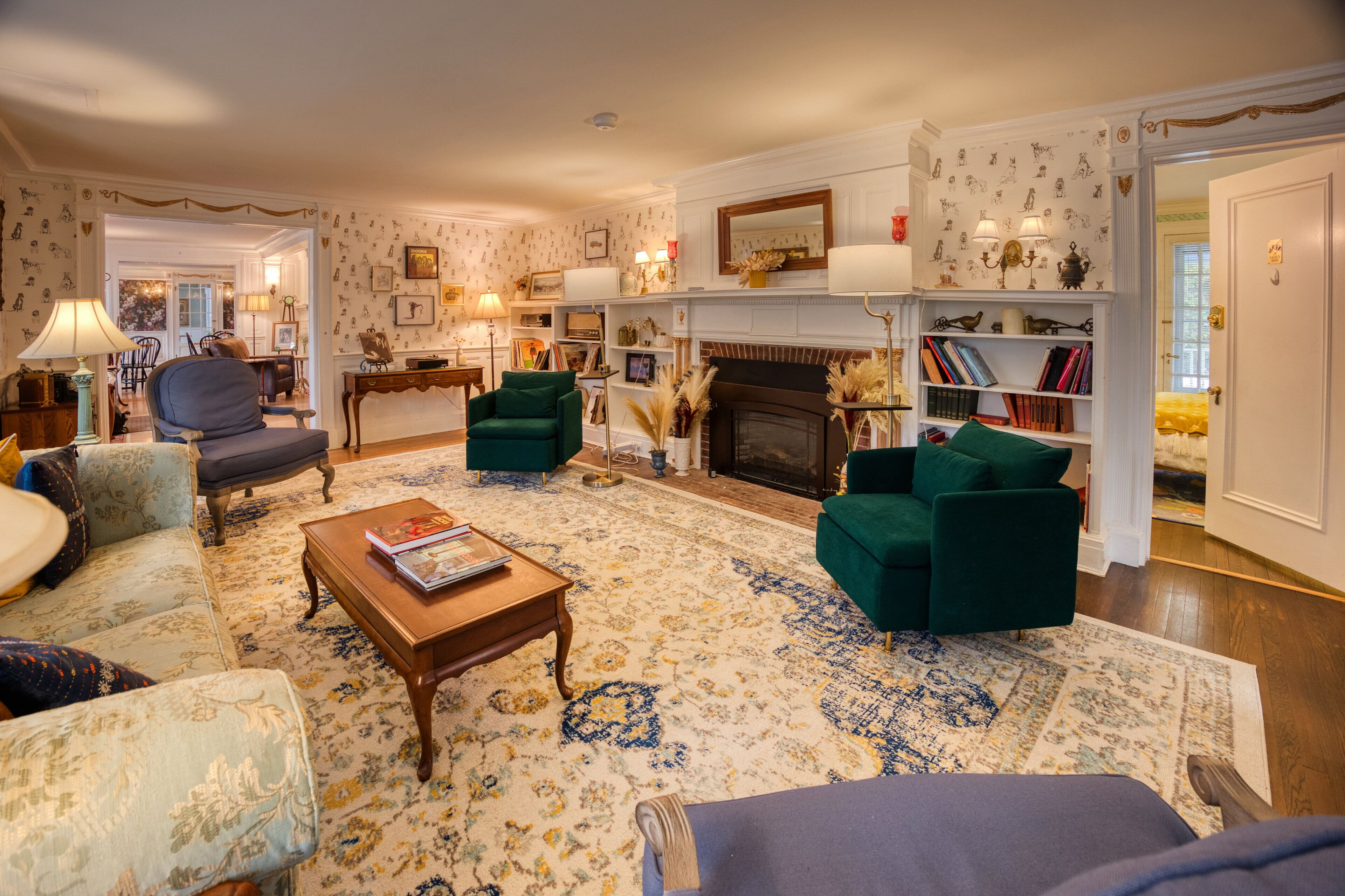 Un salon traditionnel avec une cheminée, une bibliothèque et un coin repas.