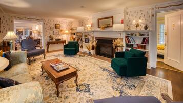 Un salon traditionnel avec une cheminée, une bibliothèque et un coin repas.