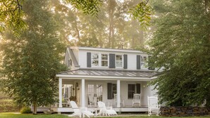 A two-story house with a porch and outdoor seating area. - Hill Farm Inn (Arlington)