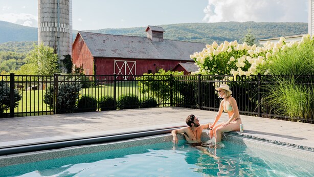 A swimming pool with a view of a barn and mountains in the background. - Hill Farm Inn (Arlington)
