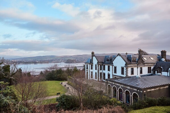 A large, light blue building with a prominent entrance and a view of a body of water in the background. - Gleddoch Golf & Spa Resort, WorldHotels Distinctive (Port Glasgow)