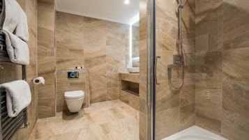Een bad/douchecombinatie, designer toiletartikelen, een haardroger