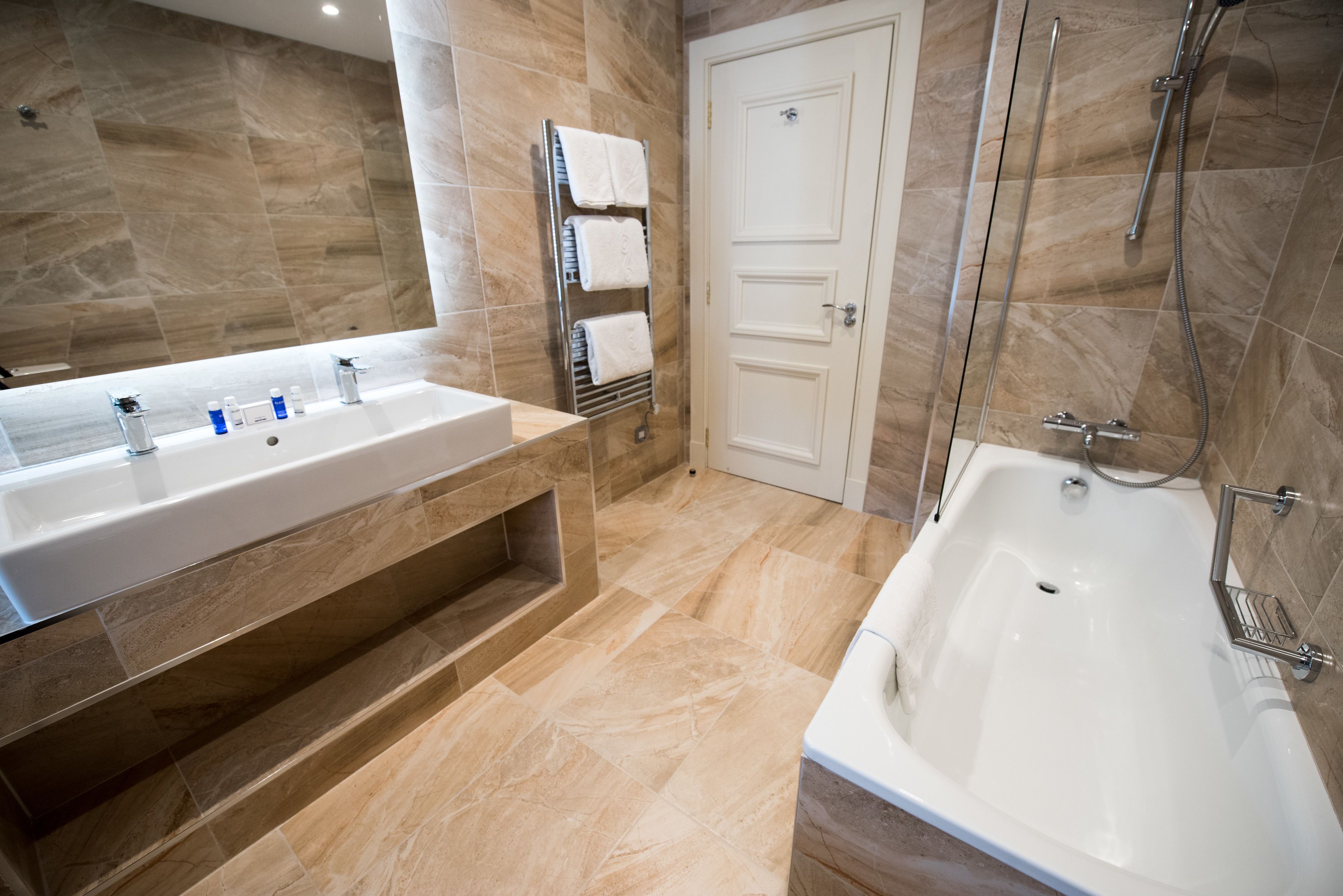 A modern bathroom with a large sink, a bathtub, and a shower.