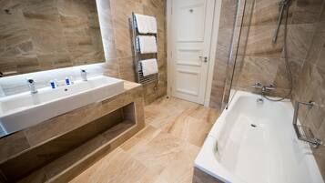 A modern bathroom with a large sink, a bathtub, and a shower.