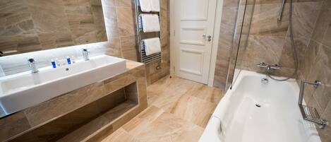 A modern bathroom with a large sink, a bathtub, and a shower.
